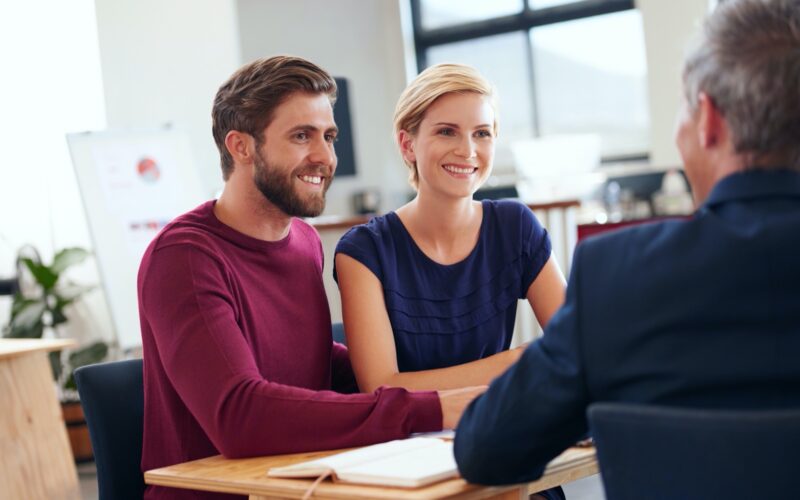 Young couple discussing investment plans with a financial advisor.